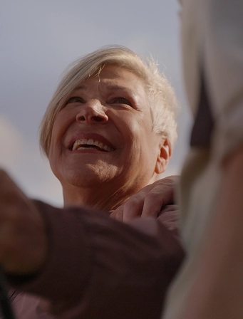 Mujer mayor sonriendo a otra persona, ejemplo de comunicación cercana en la silver economy.
